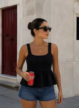 Top musculosa tejido de color negro, con escote cuadrado, tirantes anchos y corte con vuelo en la cintura tipo peplum.