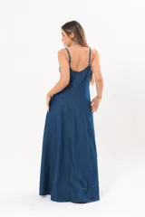 Vestido largo de denim fino y liviano, color azul, con breteles finos, escote en V y falda amplia con recortes verticales y bolsillos laterales.