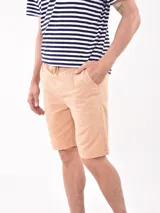 Bermuda de gabardina color beige, con cintura elástica y cordón ajustable, bolsillos laterales y corte recto.