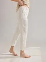 Pantalón cigarette blanco de lino, con pinzas en la pierna trasera y detalles de costuras en contraste.