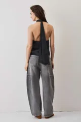 Blusa crop azul oscuro con cuello alto y diseño sin mangas, de tela con caída suave y ligero brillo.