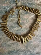 Collar corto de piedras naturales en bruto en tonos dorados y azules, con cadena de eslabones y cierre ajustable metálicos.