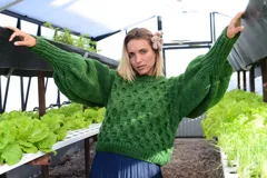 Sweater verde de lana merino, tejido a mano con punto panal y cuello a la base. Presenta mangas voluminosas con trenza central y puños muy anchos.