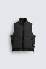 Chaleco acolchado de corte regular fit en tejido técnico con acabado efecto engomado. Presenta cuello subido, cierre frontal con cremallera, bolsillos laterales con cierre y bajo ajustable con elástico.