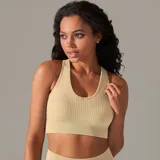 Top deportivo color beige, de tejido acanalado, con espalda deportiva y abertura en forma de gota.