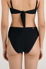 Calzón de bikini tiro alto color negro, con detalles fruncidos en los laterales de la cintura y diseño de cobertura amplia.