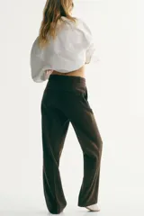 Pantalón sastrero de sarga en color verde oscuro, de corte recto con pliegues frontales, cintura clásica con presillas y bolsillos al bies.