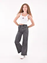 Musculosa corta de tejido acanalado color verde menta, con escote redondo y tirantes anchos. Presenta un pequeño bordado frontal con forma de flor o mariposa en tonos rosados.