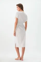 Túnica blanca de ratier de algodón con detalles de puntilla en el escote y lazo para ajustar en la cintura.