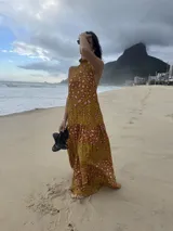 Vestido largo marrón de crepe texturizado, con cuello halter fruncido, diseño holgado y falda larga con vuelo.