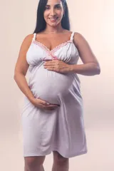 Camisón maternal de modal color blanco con detalles de puntilla rosada en el escote. Presenta breteles regulables con clip para lactancia y elástico bajo el busto para mayor sujeción.