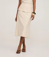 Pollera midi color crema, de corte evasé, confeccionada en tejido twill. Presenta un canesú sobrepuesto a la altura de la cintura.