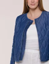 Campera corta azul de lyocell con acabado matelaseado en patrón de ondas, escote redondo, cierre frontal con cremallera y manga larga.