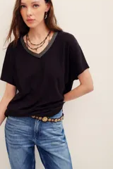 Remera negra de corte holgado, con escote en V ribeteado en hilo brillante y mangas cortas.