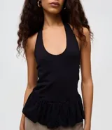 Blusa de algodón color blanco con diseño frente única, bretel posterior y ruedo con volado peplum que aporta volumen. Presenta un corte ajustado en el torso y silueta moderna.