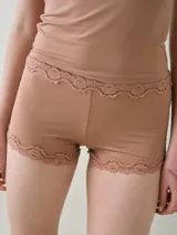 Micro short de tiro bajo color tostado, confeccionado en microfibra, con delicados detalles de encaje en la cintura y en las piernas.