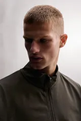 Sudadera relaxed fit gris claro melange de tejido ligero con mezcla de algodón, cuello subido, manga larga y cierre frontal con cremallera. Cuenta con bolsillos laterales ocultos y acabados en rib.