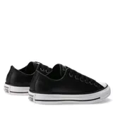 Championes Converse modelo Chuck Taylor All Star de corte bajo, confeccionados en cuero negro con textura granulada. Presentan puntera de goma blanca, ojales metálicos y suela de goma vulcanizada con franja negra decorativa.