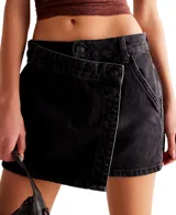Minifalda negra de denim con diseño cruzado y cierre lateral con botones.