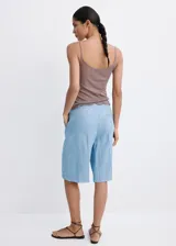 Short de denim suave color celeste claro, de tiro bajo, silueta recta y largo midi, con diseño de cinco bolsillos y costuras frontales marcadas.