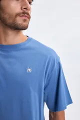 Remera de manga corta con corte oversize, color azul piedra, con estampa gráfica en la espalda que incluye el texto 'Miles Morales Spider-Man Brooklyn New York'.