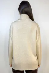 Sweater beige de cuello alto con abertura frontal y corte holgado.