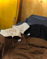 Buzo de pana negra con cierre frontal parcial, cuello alto y forro interior de corderito. Presenta diseño de corte oversized, bolsillos laterales y puños elásticos.