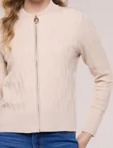 Cardigan tejido con cierre frontal de la marca Rio & Rian, de silueta entallada y estilo bomber, color beige. Cuenta con cuello a la base, cierre metálico completo, textura labrada en relieve en el frente y las mangas, mangas largas con puños acanalados y ruedo recto.