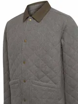 Chaqueta RKF modelo Lewis de corte regular, confeccionada en lana con diseño acolchado de rombos. Presenta cierre frontal con broches metálicos, bolsillos frontales aplicados, cuello camisero de cotelé en tono contrastante y relleno térmico de fibras recicladas.