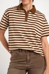 Remera polo de manga corta con diseño a rayas horizontales en tonos marrones, beige y negros, cuello en contraste y cierre frontal de botones.