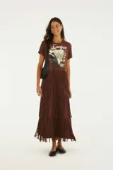 Vestido largo marrón de algodón con estampa frontal inspirada en Río de Janeiro que incluye un tucán y la inscripción 'Carioca', manga corta y falda larga adornada con múltiples niveles de flecos.