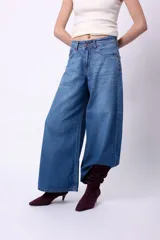 Jean de tiro alto con corte wide leg, confeccionado en denim azul clásico. Presenta etiqueta de cuero en la parte posterior y bolsillos traseros tradicionales.
