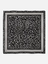 Pañuelo cuadrado con diseño central de estampado animal print en tonos grises y negros, enmarcado por bordes lisos y detalles decorativos en los extremos.