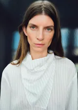 Blusa de manga larga con diseño de rayas verticales, cuello redondo y pañuelo integrado al tono. Presenta un corte recto y cierre de botón en la parte posterior.