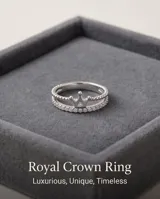 Anillo de plata 925 con diseño de corona y detalles de circonias cúbicas brillantes, acompañado por una alianza fina decorada con pequeñas piedras incrustadas.