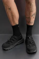 Sandalia deportiva negra con aberturas laterales para ventilación, puntera reforzada, ajuste con cordones y suela de goma.