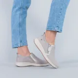 Zapatos slip on de gamuza en color gris, con suela blanca y detalle de cierre lateral funcional.