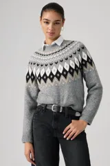Sweater de punto con diseño Fairisle en el canesú, cuello redondo, manga larga y puños acanalados. Presenta un patrón geométrico en tonos gris, negro, blanco y beige sobre una base gris jaspeado.