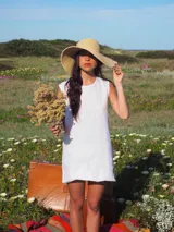 Vestido corto color blanco, sin mangas, con cuello redondo y diseño de corte recto y holgado.