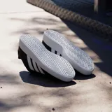 Championes Adidas modelo Grand Court Base 3.0, de diseño urbano con exterior de cuero sintético negro y las icónicas tres rayas laterales en color blanco. Presenta cierre con cordones al tono y suela de goma blanca con logo grabado en el lateral.