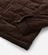 Campera puffer de Marfinno confeccionada en tejido de cotelé de algodón, con diseño acolchado, cuello inglés, cierre frontal con botones y dos bolsillos con solapa en el pecho.