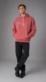 Hoodie rosado con capucha, cordones ajustables blancos y bolsillo tipo canguro al frente. Presenta pequeños estampados en el pecho.