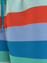 Short de baño Tommy Hilfiger con estampado a rayas horizontales en tonos celeste, azul, verde y naranja.
