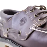 Zapato náutico de cuero color marrón con cordones, detalle de costuras en contraste y suela de goma.