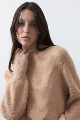 Polera de tejido de punto en color marrón oscuro, con cuello alto y diseño de silueta relajada.