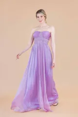 Vestido largo de fiesta color lila, sin mangas, con escote palabra de honor, drapeado en el busto y aplicaciones de bordados al tono.