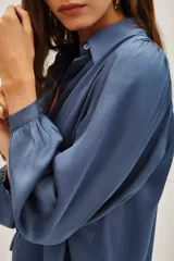 Camisa de viscosa en color marrón, con cuello clásico, cierre frontal de botones y mangas largas con puños abotonados.