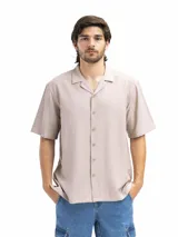 Camisa de manga corta color beige claro, con cuello cubano y corte suelto.