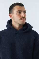 Canguro de sherpa polar color beige, con capucha, bolsillo tipo canguro y logo de goma en el pecho.