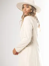 Tapado largo color beige, de corte recto y manga larga.